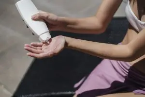 Jak wybrać krem z filtrem do twarzy z przebarwieniami? Faceless woman applying lotion on hand on sunny day
